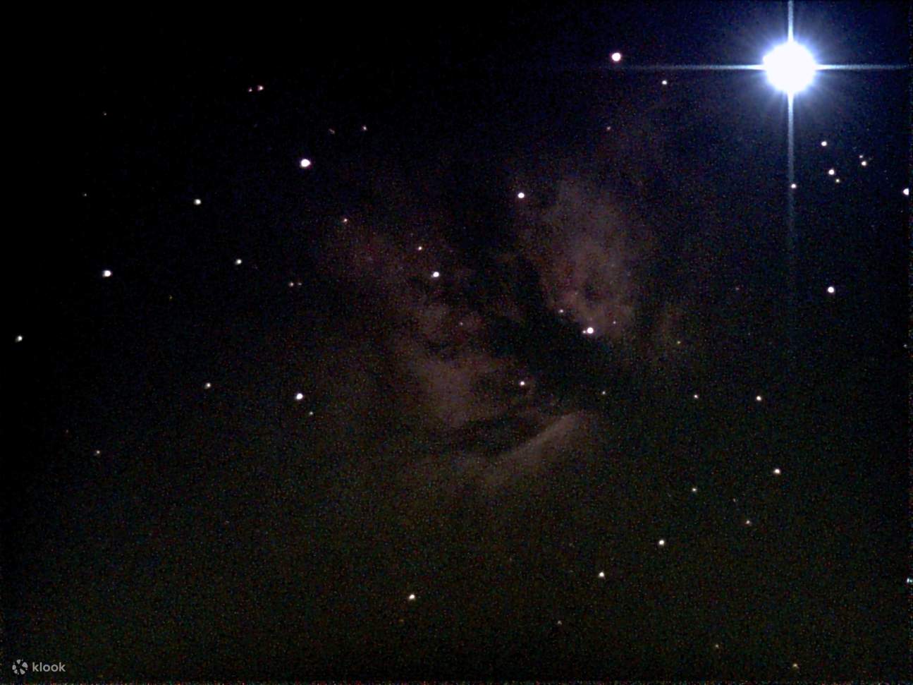 通过望远镜可以看到明亮的星团，展示了在太空中发光的新生恒星