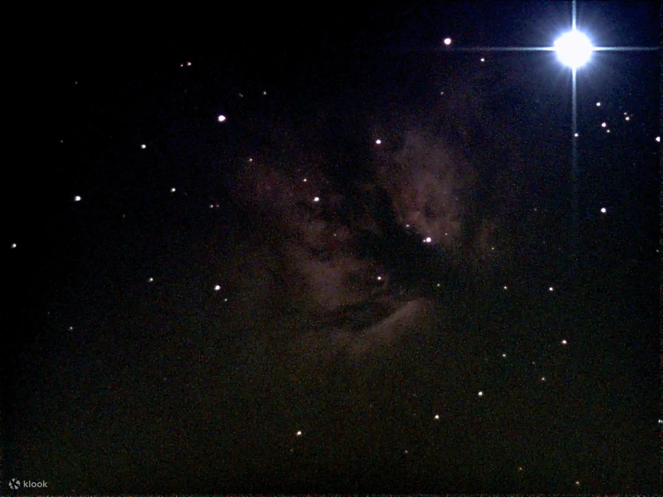 通过望远镜可以看到明亮的星团，展示了在太空中发光的新生恒星