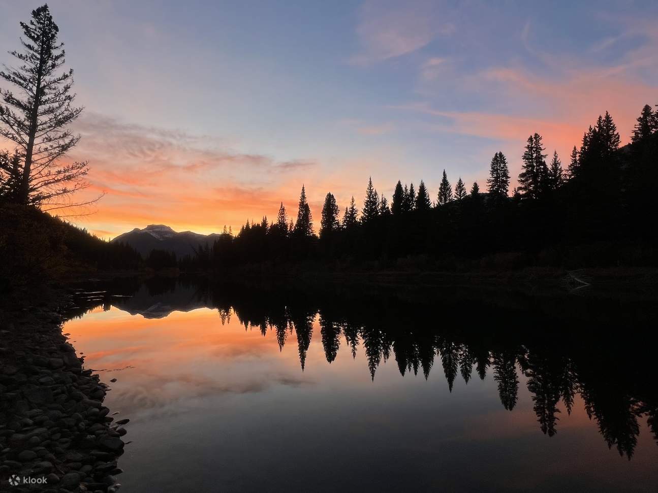 Ígneos tonos del atardecer pintando el agua y los picos en vibrantes rojos y naranjas