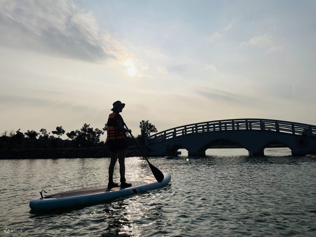 เด็กชายกำลังถือกระดาน พร้อมที่จะเริ่มการเดินทางเพื่อประสบการณ์การเล่นแพดเดิลบอร์ดแบบสแตนด์อัพ