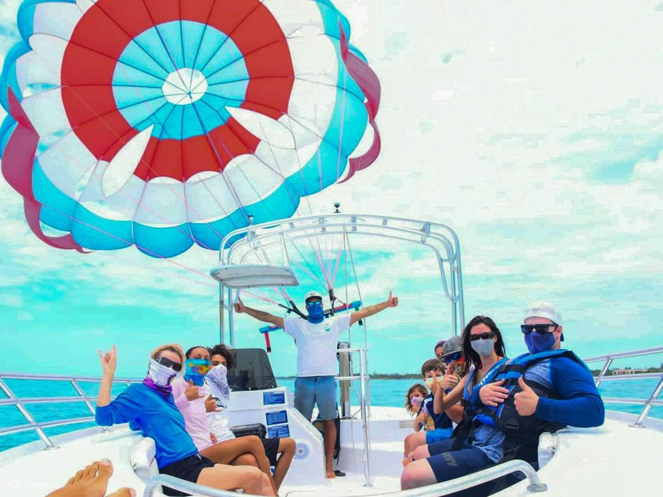 Tạo dáng trên thuyền với dù lượn trước khi bay lên bầu trời