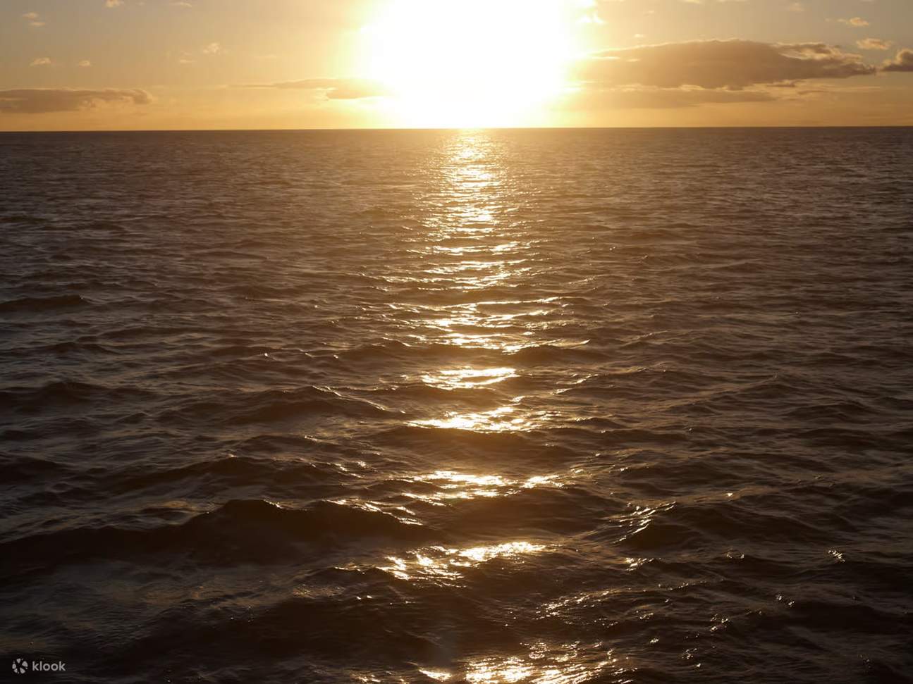 Watch vibrant sunset hues merge with calm sea along horizon line