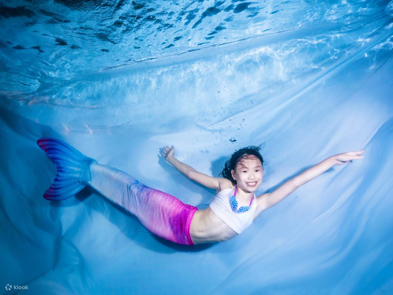 Một bé gái tạo dáng như nàng tiên cá nhỏ