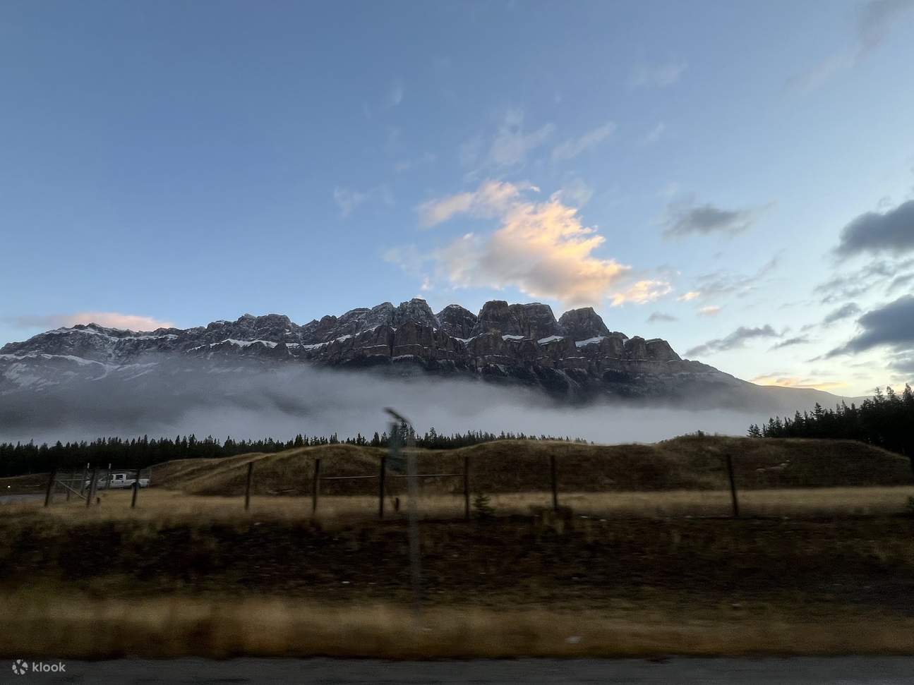 Der hoch aufragende Castle Mountain, der im späten Nachmittagssonnenlicht golden leuchtet, mit dramatisch aufragenden Klippen