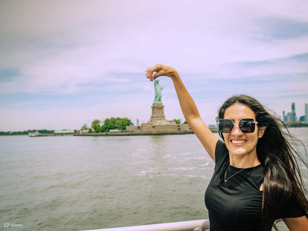 L'emblématique Statue de la Liberté se dresse fièrement de l'autre côté du fleuve, symbole de la liberté.