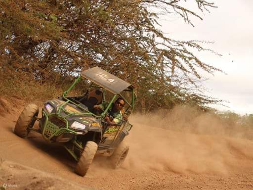 Primer plano de ruedas de ATV salpicando al cruzar una zona de agua poco profunda y fangosa