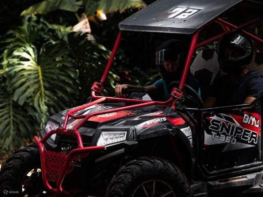Dos conductores a toda velocidad por senderos selváticos embarrados en un robusto vehículo todo terreno de dos plazas