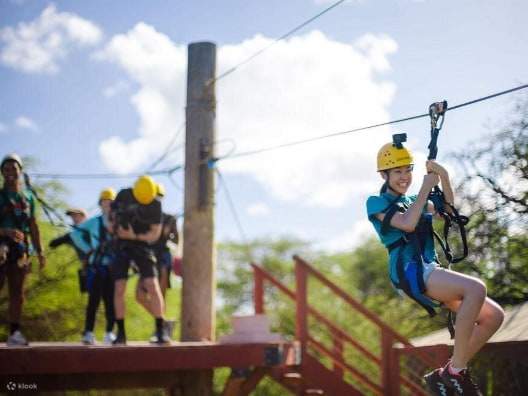 Piattaforma zipline con guide che assistono i partecipanti e si assicurano che l'equipaggiamento di sicurezza sia fissato correttamente