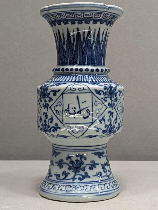 The Ming Zhengde Blue and White Arabic Script Lotus Pattern Zun is a ceramic piece from the Ming Dynasty, specifically from the Zhengde period (1506-1521). This artifact is shaped like a traditional bronze Zun and is decorated with Indian lotus patterns a