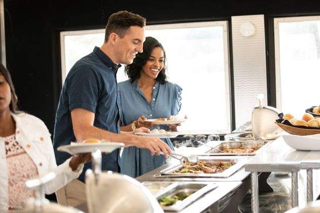 Dos parejas sirviéndose comida del buffet