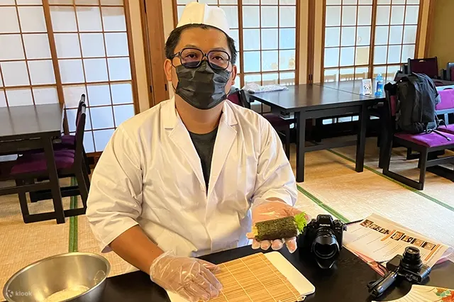 一个男人正在展示他的寿司卷