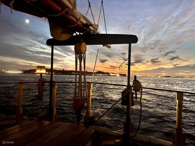 Une douce lumière dorée se répand sur l'horizon dégagé, diffusant une lueur tranquille sur le ciel et l'eau environnants.
