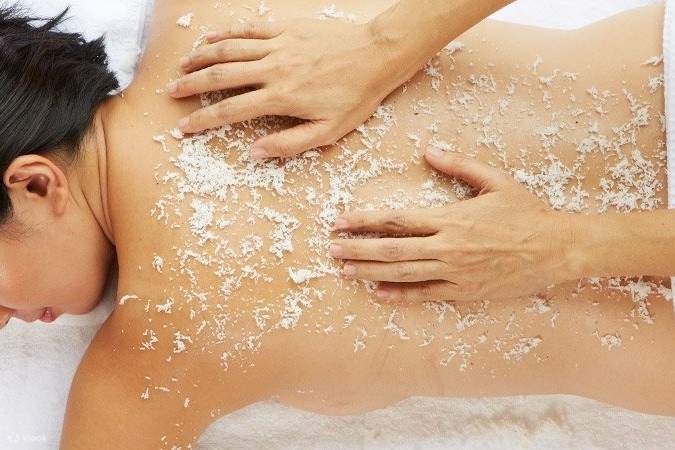 在背上敷椰子片進行按摩的女子