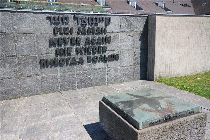 words on the wall saying 'never again' in different languages