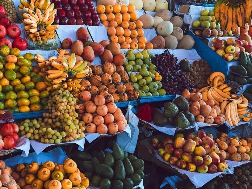 A vibrant market scene filled with colorful fruits, fresh produce, and lively vendors