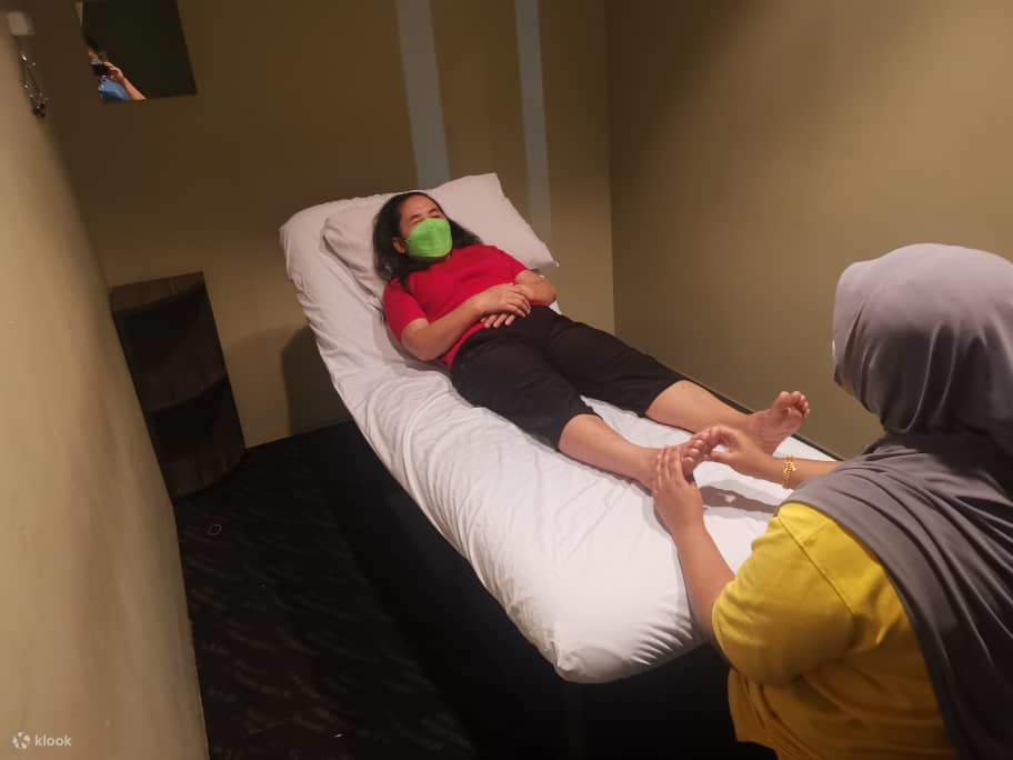 นวดเท้าโดยนักบำบัดผู้พิการทางสายตาที่เป็นผู้หญิง 