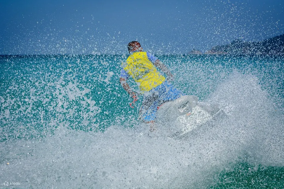 person with a yellow vest riding a jet ski viewed from the back