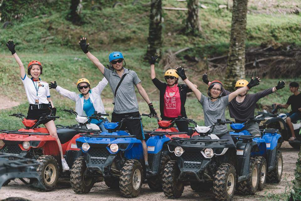 Sekelompok orang berpose untuk kamera saat mengendarai ATV