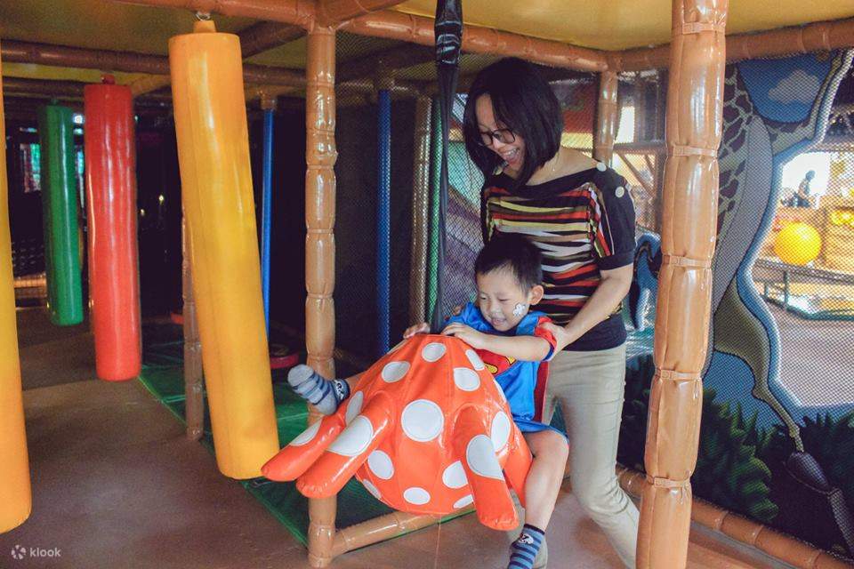 madre jugando con su hijo en el parque infantil