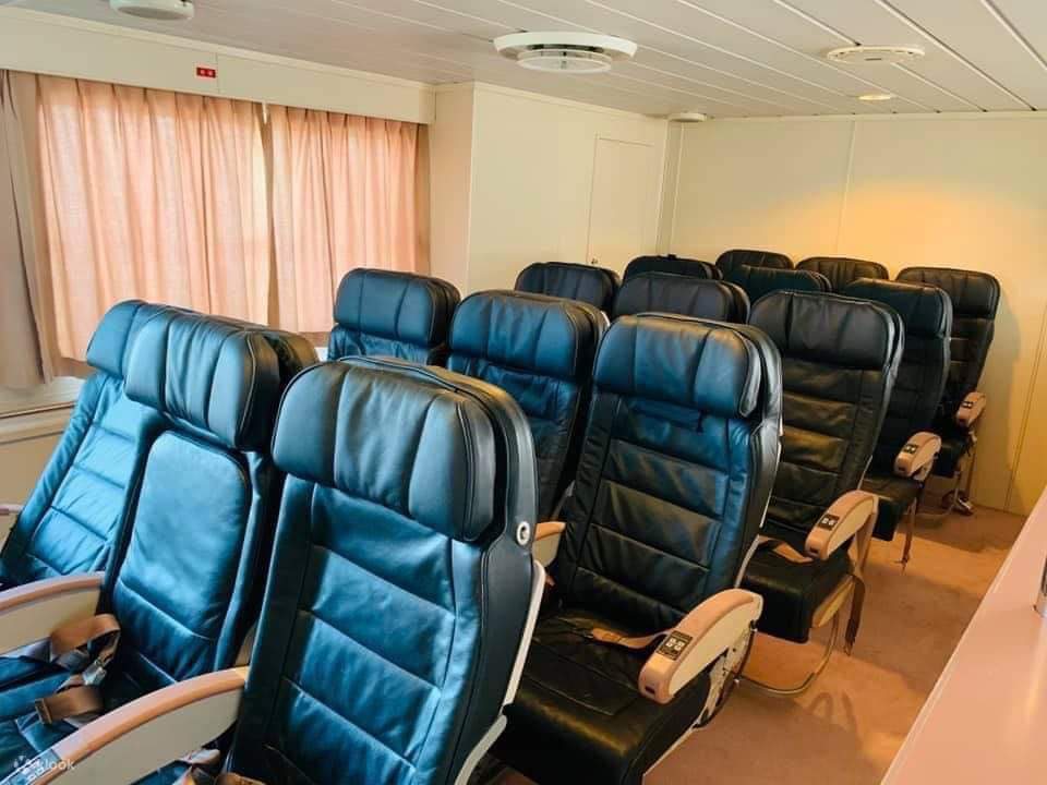 渡輪內座位區的景觀，奶油色、紫色和紅色的座位排列成3列，每列3個座位