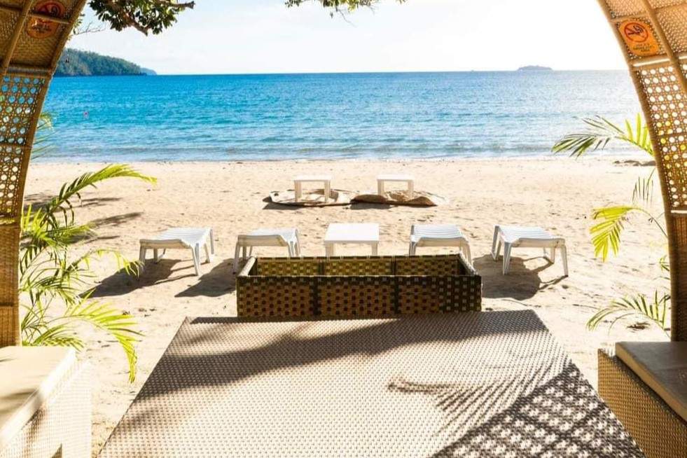 Пляж с пустыми шезлонгами, обращенными к бескрайнему океану