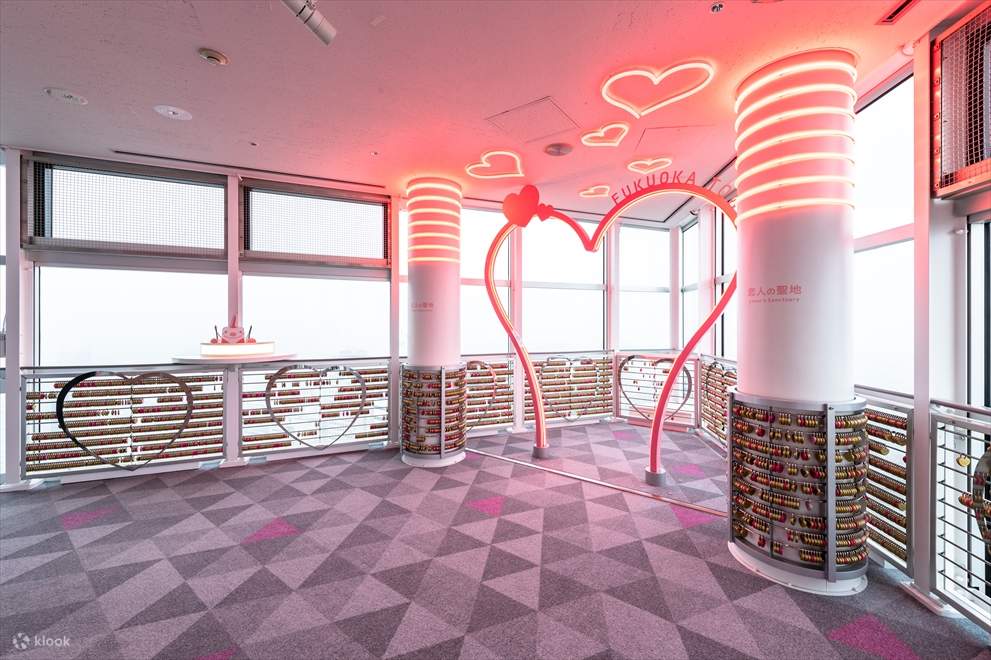 情侶在福岡塔的心形裝飾前漫步