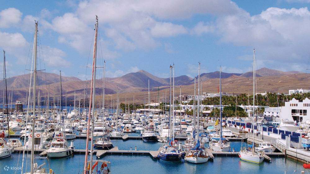 Admire los yates de lujo en el puerto deportivo de Puerto Calero mientras navega hacia el encantador casco antiguo de Puerto del Carmen.