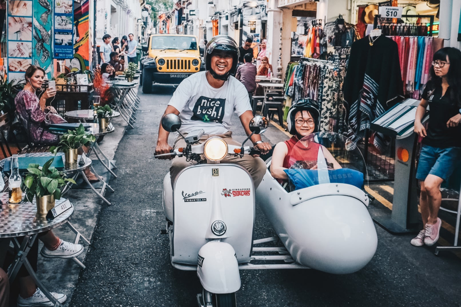 Vespa sidecar passing colourful heritage shophouses