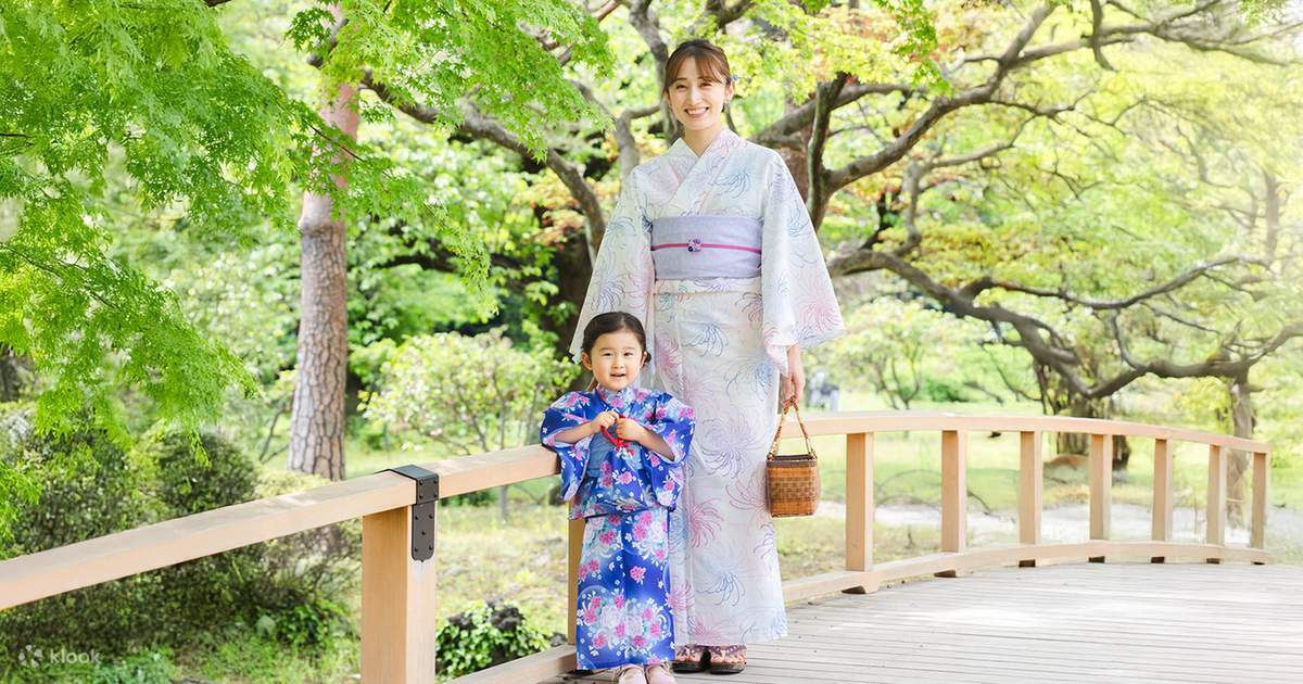 Wanita mengenakan kimono tradisional berjalan di bawah pohon sakura musim semi di Jepang