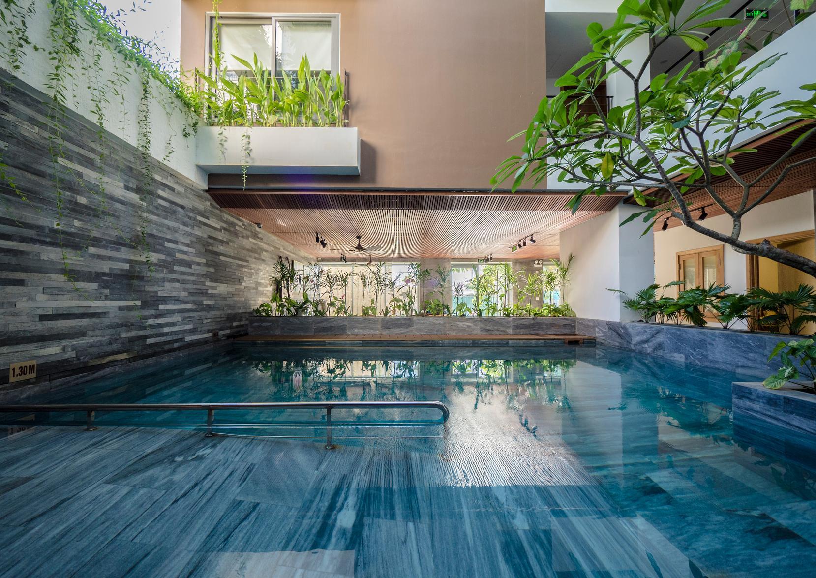 Hồ bơi trong nhà xanh mát, được bao quanh bởi cây xanh, mang đến không gian thư giãn yên tĩnh và gần gũi thiên nhiên.